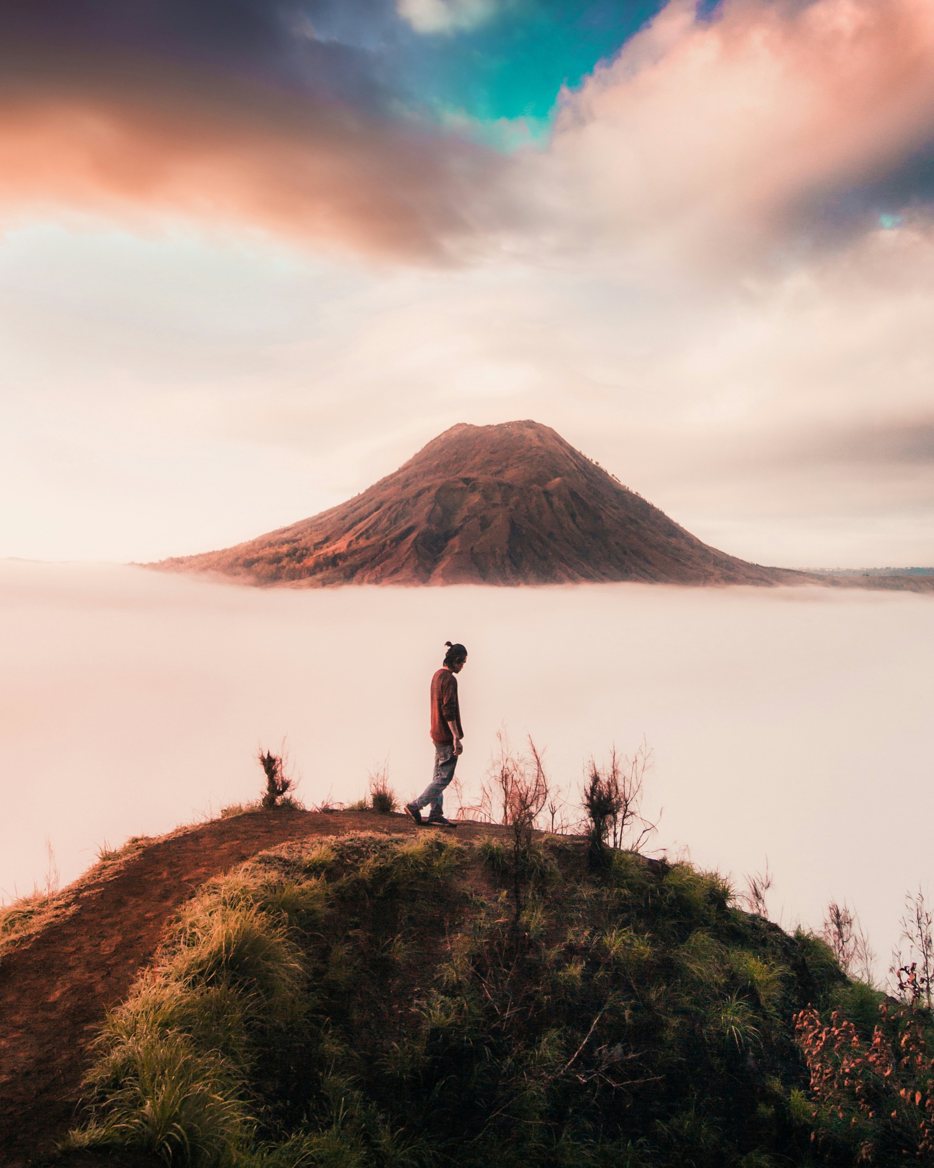 A person standing alone above the clouds — perspective and solitude